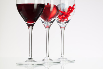 Wine glasses with red wine, heart and golf ball