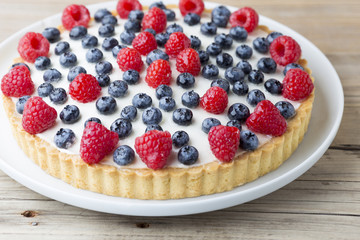 Cake with blueberries and raspberries. Confectionery product.