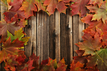 Autumn leafs frame on brown wooden background