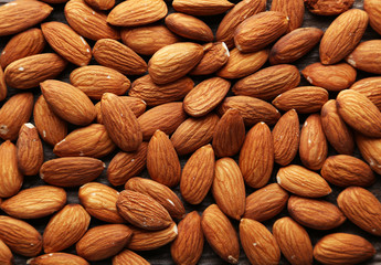 Almonds on brown wooden background