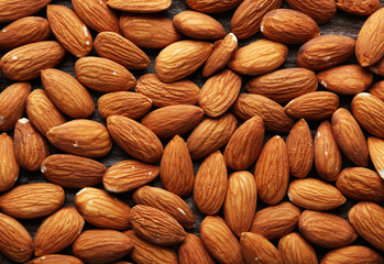 Almonds on brown wooden background