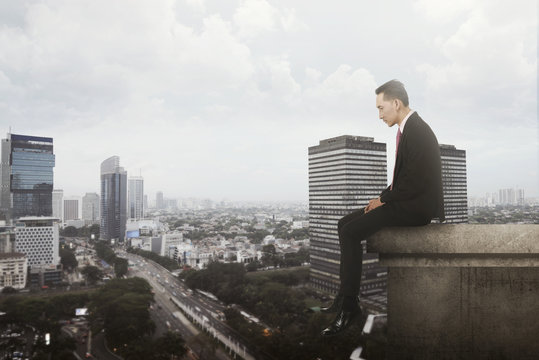 Business Man Sitting On Rooftop