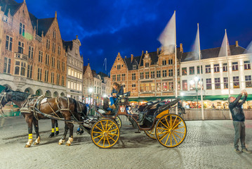 Naklejka na ściany i meble Night view of Horse Carriage in Bruges main square
