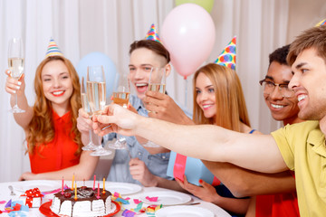 Young people celebrating a birthday sitting at the table