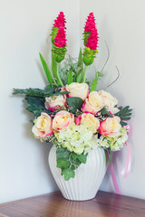 Beautiful Fake Flowers in Whie pot on wood table, cool tone