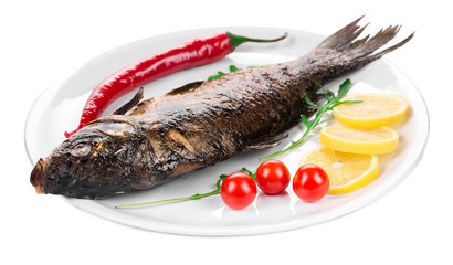 Grilled carp with vegetables on plate.