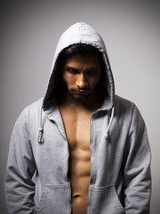 Hombre musculoso con sudadera gris con capucha