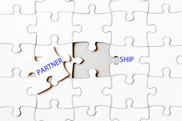 Fototapeta premium Missing jigsaw puzzle piece completing word PARTNERSHIP