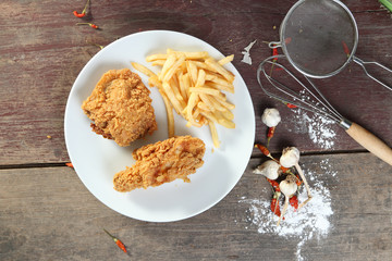fried chicken wings with french fries on wood table. view from a