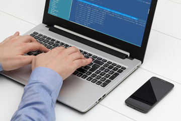 Developer working on source codes on laptop at office