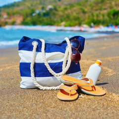 Beach bag, flip flops, and sunscreen bottle