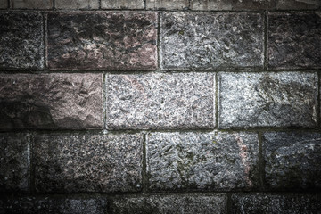Old wall from marble blocks covered with moss