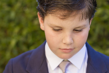 Boy first communion dress looking down