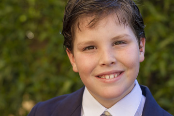 Boy first communion dress smiling to the camera