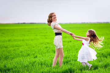 Happy mother and daughter in the meadow