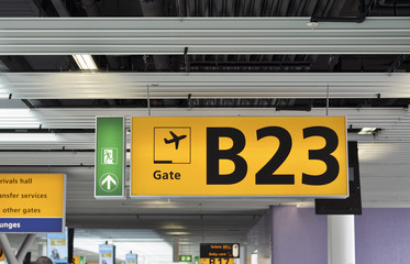 Yellow illuminated sign at airport with gate number 