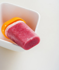 Strawberry ice cream stick close up on white