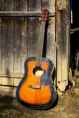 Fototapeta premium Classical guitar leaning against wooden door