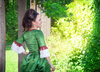 Beautiful young woman in green medieval dress