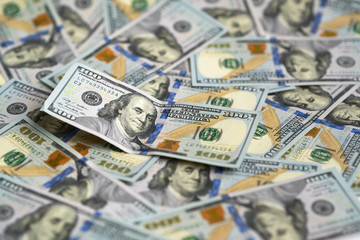 hundred dollar bill on  pile of money