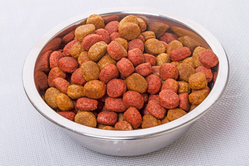 Dry dog food in a metal bowl