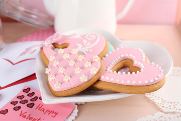 Heart shaped cookies for valentines day on plate, on color wooden background