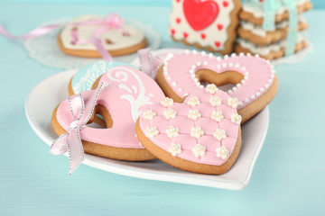 Fototapeta na wymiar Heart shaped cookies for valentines day on plate, on color wooden background