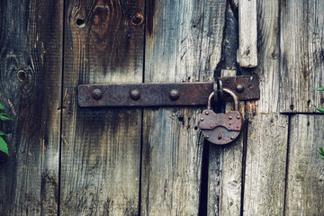 wooden wall and a door with an old rusty lock