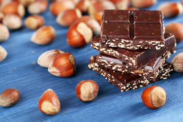 Pieces of chocolate with hazelnut on wooden table, closeup