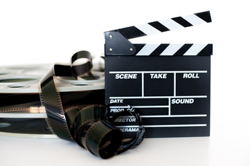 Fototapeta premium Movie clapper and vintage 35 mm film cinema reel on white
