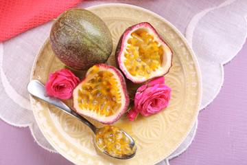 Passion fruit on plate on color wooden background