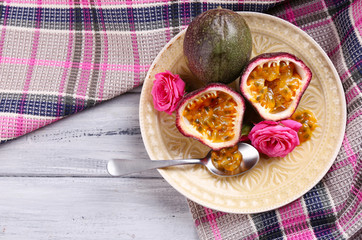 Passion fruit on plate on color wooden background
