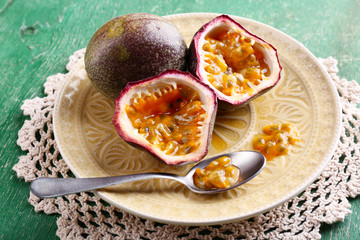 Passion fruit on plate on color wooden background