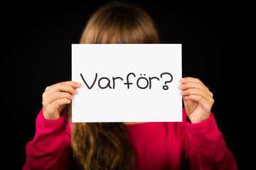 Child holding sign with Swedish word Varfor - Why