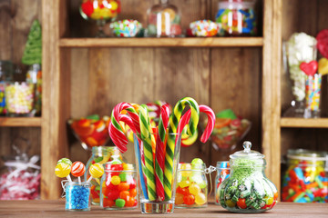 Colorful candies in jars on table in shop
