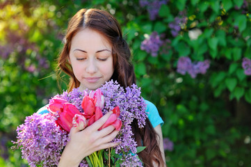 Fototapeta premium beautiful woman with a bouquet walking in the garden