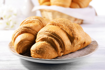 Delicious croissants on plate on table close-up