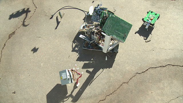 Computer Components Crash. A pile of broken and obsolete computer components is dropped onto concete. Shot in slow motion at 60fps.