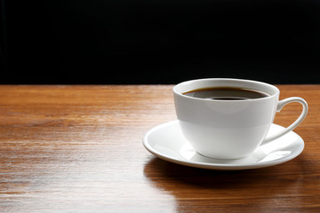 Cup of coffee on table on dark background