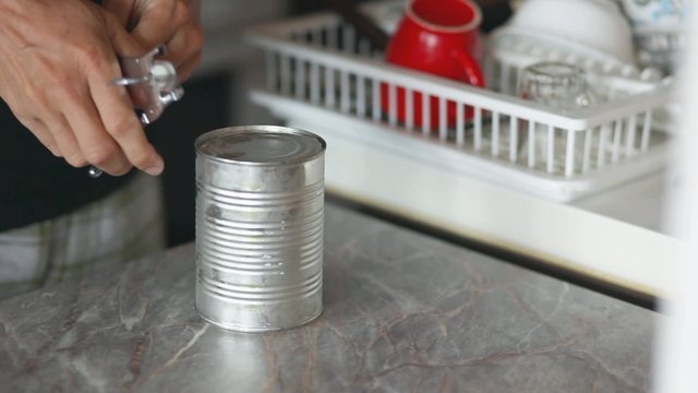 Can opening using can opener, closeup stock footage