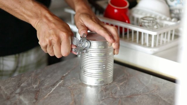 Can opening using can opener, closeup stock footage
