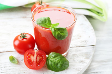 Glass of fresh tomato juice on wooden table, closeup