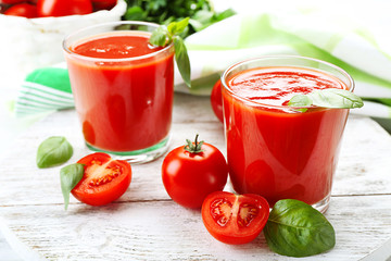 Glasses of fresh tomato juice on wooden table, closeup