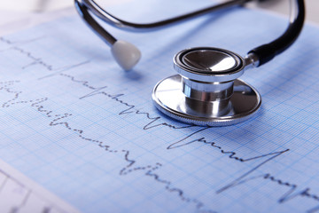 Cardiogram with stethoscope on table, closeup