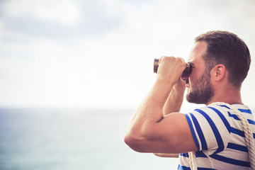 Sailor man looking through the binoculars - obrazy, fototapety, plakaty