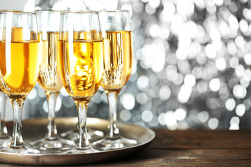 Glasses of champagne on bright background