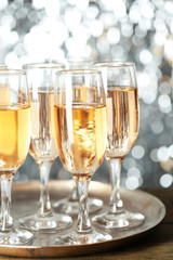 Glasses of champagne on bright background