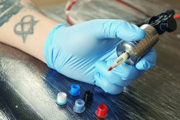 Tattoo artist at work close up