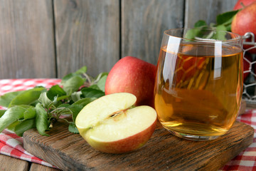 Glass of apple juice on wooden background