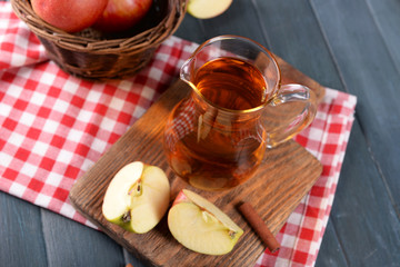 Glass jug of apple juice on wooden table, closeup